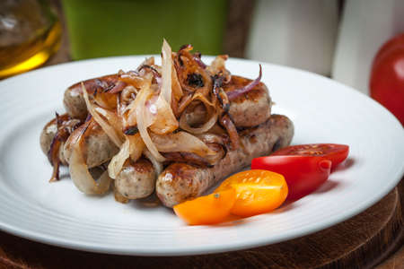 Fried white sausages with onion on the plate. Selective focus.の写真素材
