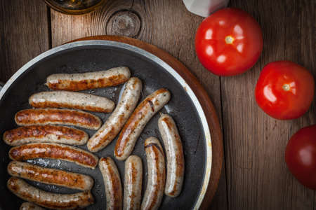 Fried white sausages in a cast iron skillet. A rustic style. Selective focus.の写真素材