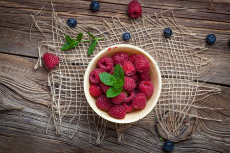 Raspberries in a waffle bowls on a wooden table. Selective focus. Top view.の写真素材