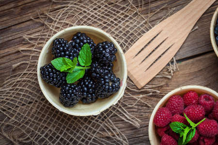 Blackberries, raspberries and blueberries in a waffle bowls on a wooden table. Selective focus. Top view.の写真素材