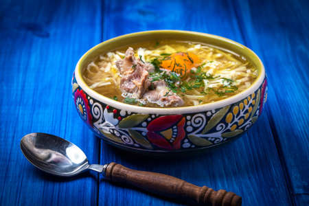 Soup with noodles and chicken in a ceramic bowl.の写真素材