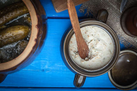 Slice of country bread with homemade lard and cucumber. Dark light.