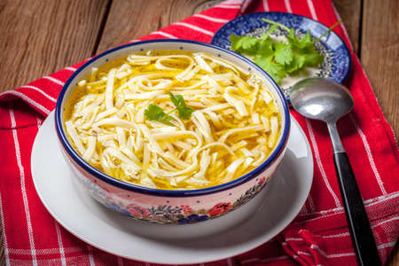 Chicken noodle soup on wooden table. Selective focus.の写真素材
