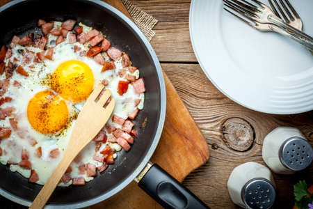 Fried eggs with chopped sausage in a pan. Top view.の写真素材