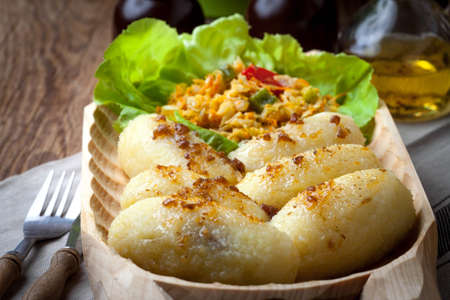 Potato dumplings stuffed with minced meat in a wooden bowl.の写真素材