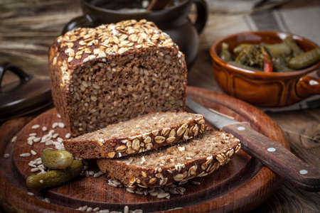 Whole Grain rye bread with seeds on a wooden board.