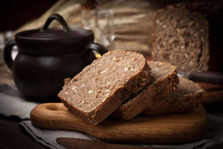 Wholemeal bread with sunflower seeds. Dark light.
