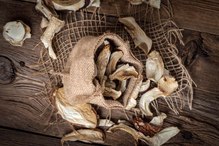 Dried wild mushrooms on a wooden table.の写真素材
