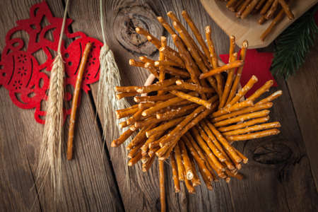 Salty pretzel sticks on a dark wooden table.の写真素材