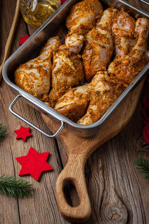 Marinated chicken drumsticks ready for baking. Dark light. Selective focus.の写真素材