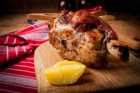Roast pork knuckle on a wooden board. Selective focus.の写真素材