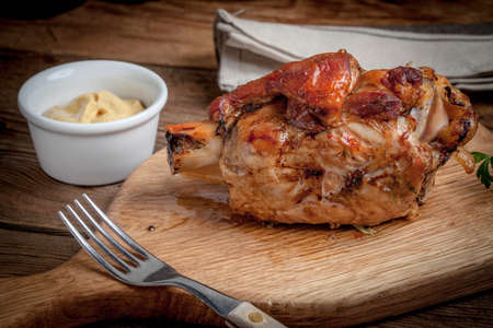 Roast pork knuckle on a wooden board. Selective focus.の写真素材