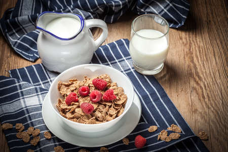 Tasty breakfast with milk and raspberries in white bowl.の写真素材