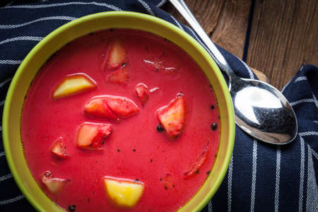 Vegetarian red soup - borsch in green bowl on wooden background.の写真素材