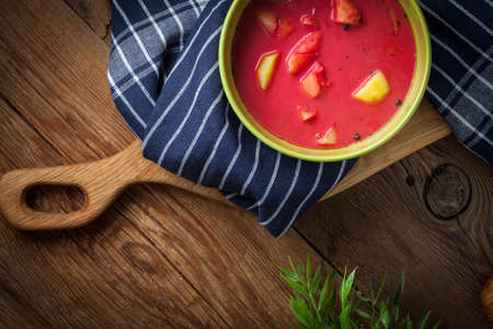 Vegetarian red soup - borsch in green bowl on wooden background.の写真素材