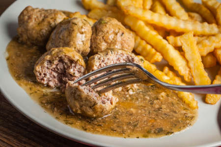 Meatballs with french fries in dill sauce and cranberry jam. Selective focus.の写真素材
