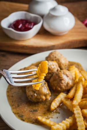 Meatballs with french fries in dill sauce and cranberry jam. Selective focus.の写真素材