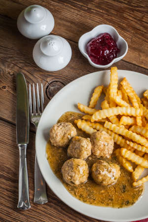 Meatballs with french fries in dill sauce and cranberry jam. Selective focus.の写真素材