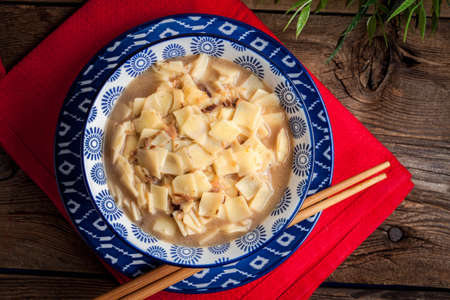 Mushroom soup with noodles in a blue bowl. Selective focus.の写真素材