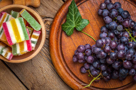 Colorful jelly candies in wooden bowl on wooden background. Selective focus.の写真素材