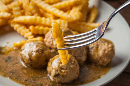 Meatballs with french fries in dill sauce and cranberry jam. Selective focus.の写真素材