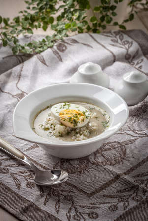 Homemade sorrel soup with egg and rice in a bowl.の写真素材