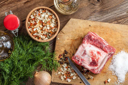 Raw brisket with bone on a chopping board.の写真素材