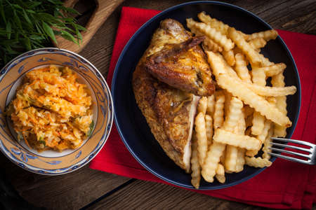 Roasted chicken with french fries on a plate. Selective focus. Top view.の写真素材