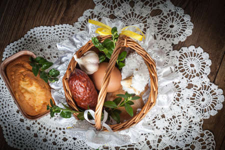 Traditional Easter basket with food on the wooden table.の写真素材
