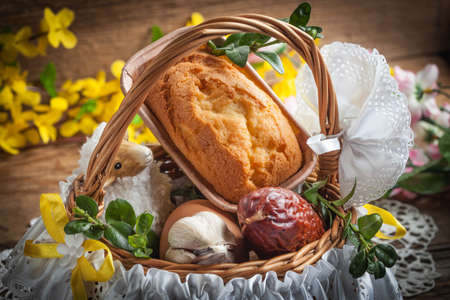 Traditional Easter basket with food on the wooden table.の写真素材