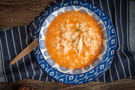 Fresh tomato soup with rice in a blue bowl. Top view.の写真素材