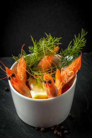 Shrimp in the cup on stone plate. Selective focus. Dark light.の写真素材