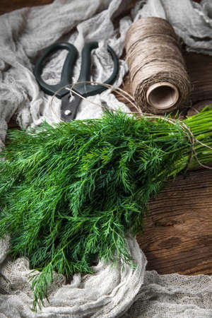 Dill. Fresh garden herbs on wooden table.の写真素材