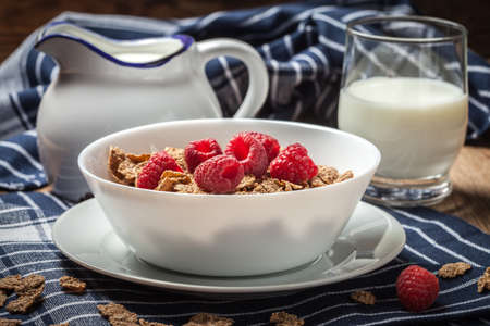 Tasty breakfast with milk and raspberries in white bowl.の写真素材