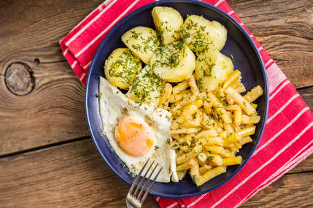 Fried egg served with boiled potatoes and yellow beans. Top view.の写真素材
