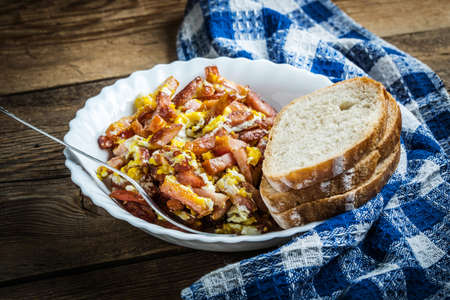 Pieces of sausage fried with egg in bowl.の写真素材