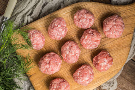 Raw meatballs on the wooden cutting board. Small depth of field.の写真素材