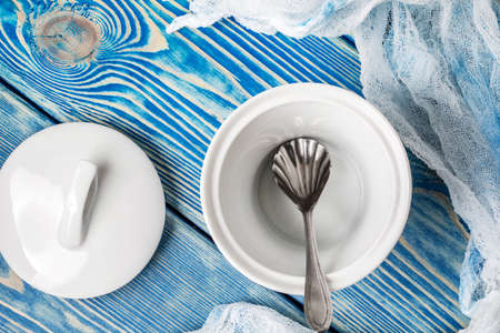 Empty sugar bowl on a blue wooden table.