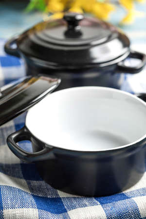 Mini black empty casserole on wooden table.の写真素材