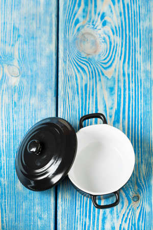 Mini black empty casserole on wooden table. Top view.の写真素材