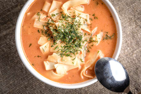 Fresh tomato soup with noodles in white bowl.の写真素材