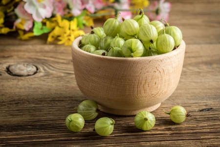 Fresh gooseberry in a wooden bowl. Small depth of field.の写真素材