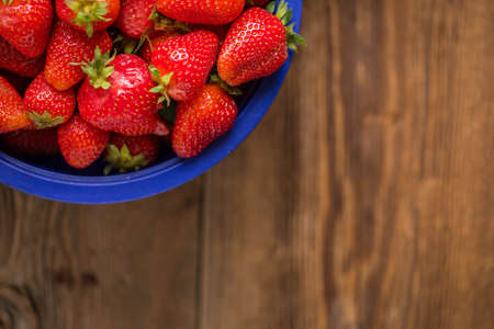 Fresh strawberries from a home garden in a colander. Top view and copy space.の写真素材