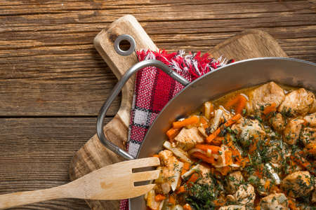 Fried chicken pieces with vegetables on a metal frying pan. Small depth of focus.の写真素材