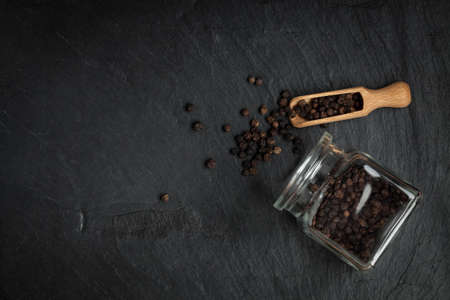Seeds of pepper scattered on a stone black background. Top view, copy space.の写真素材