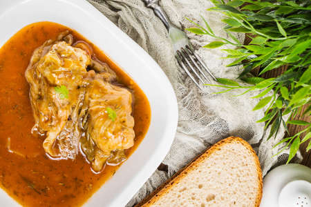 Stuffed cabbage roll served with sauce on a white plate. Small depth of field.の写真素材