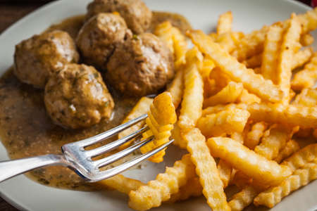 Meatballs with french fries in dill sauce and cranberry jam. Selective focus.の写真素材