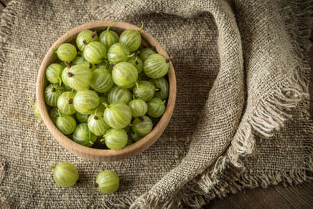 Fresh gooseberry in a wooden bowl. Small depth of field.の写真素材