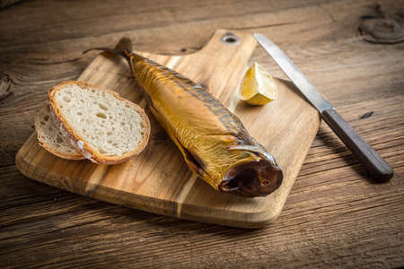 Smoked mackerel and bread on a cutting board.