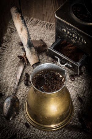 Turkish coffee in copper coffee pot on wooden background.の写真素材